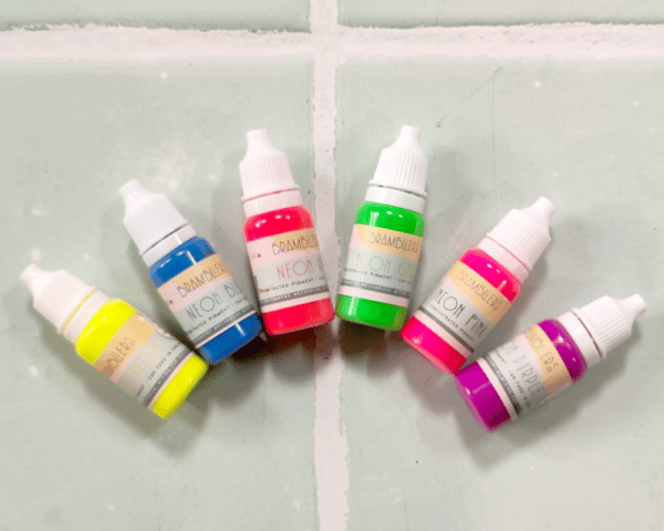 6 bottles of neon pigment arranged in an arch shape